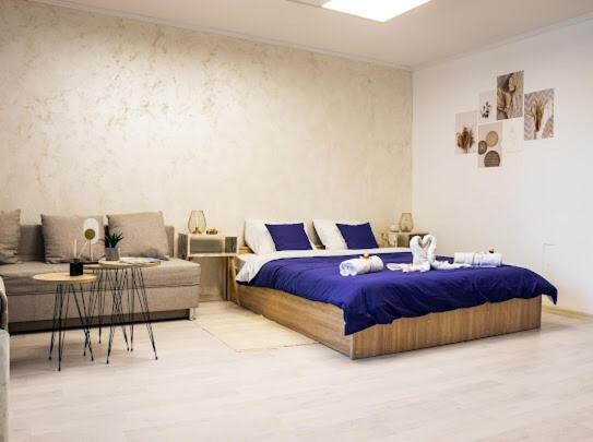 een slaapkamer met een groot bed en een bank bij Center Cozy Apartment in Subotica