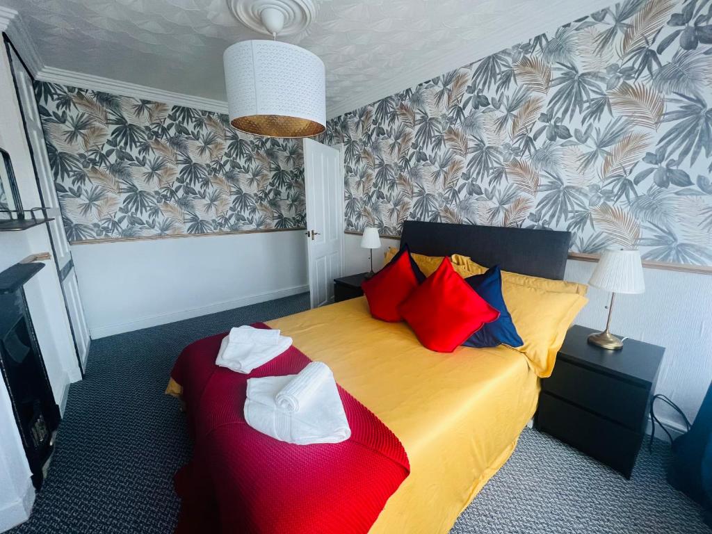 Un dormitorio con una cama amarilla con almohadas rojas y azules en Sheffield house on the hill, en Manor