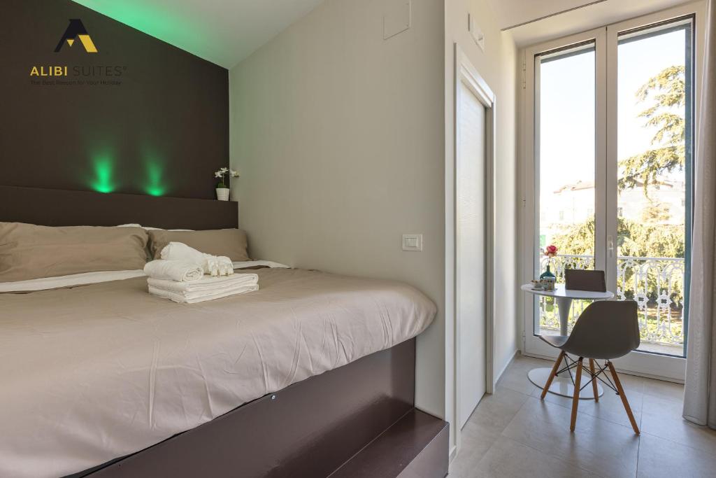 a bedroom with a bed and a chair and a window at [ALIBI SUITES] Suite MUSEUM: Gioiello con Vista sul Museo Archeologico Nazionale, Letto e Doccia con Cromoterapia, Smart tv, WiFi e A/C in Ruvo di Puglia