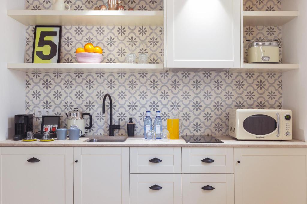 a kitchen with white cabinets and a microwave at Samaritana Suites in Palma de Mallorca