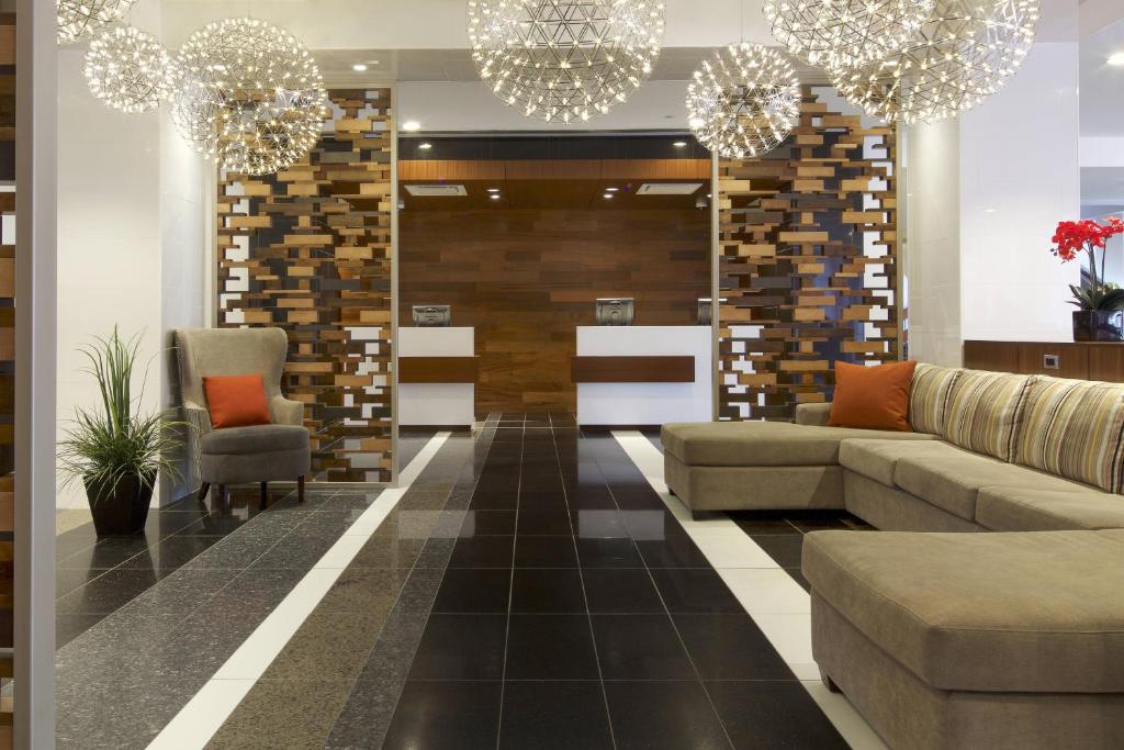 a lobby with a couch and chairs and chandeliers at Delta Hotels by Marriott Beausejour in Moncton