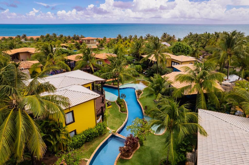an aerial view of a resort with a pool and the ocean at Domus Villas in Pipa