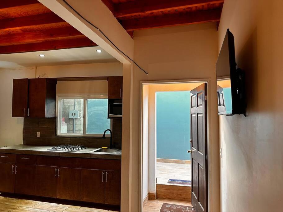 a kitchen with a view of the ocean through a door at Bonito departamento rustico in Rosarito