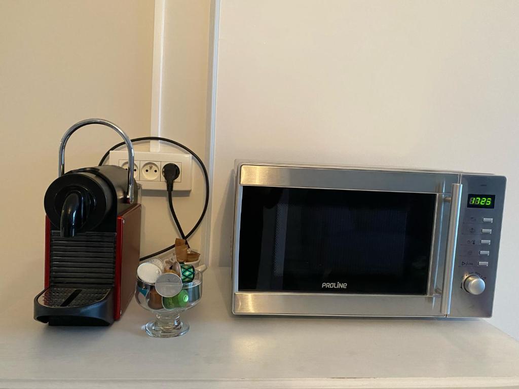 un microondas sentado en un mostrador junto a una radio en Studio en centre ville de Vendôme, en Vendôme