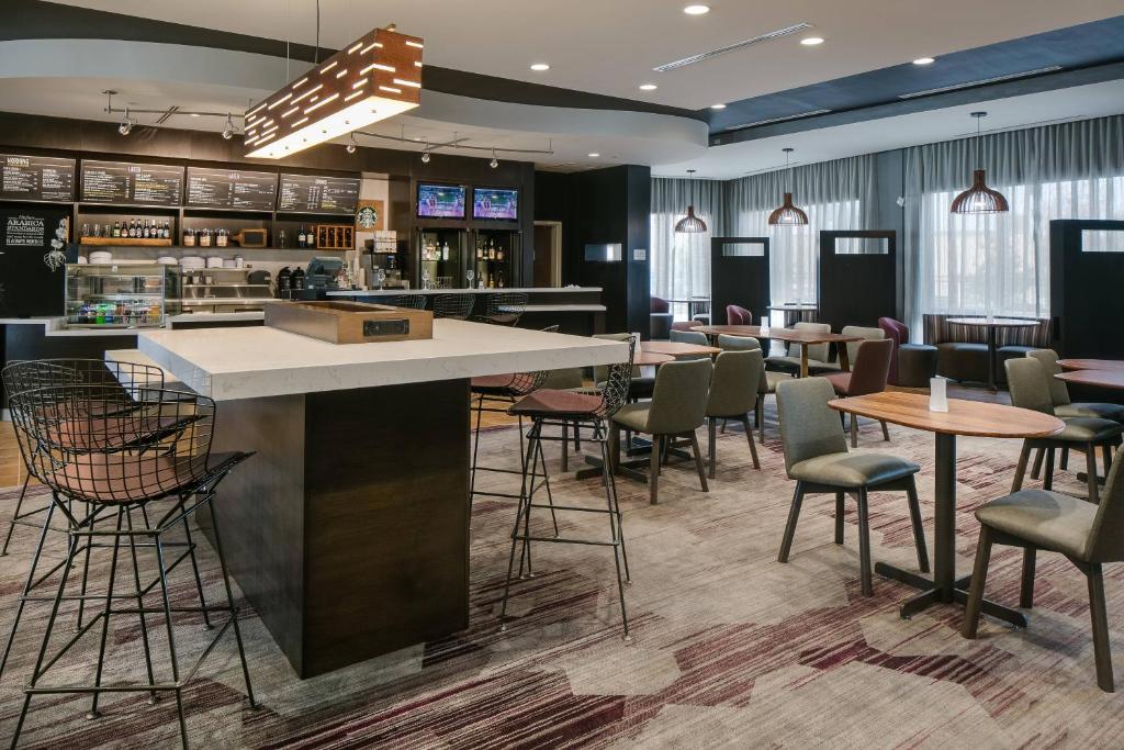 a bar in a restaurant with chairs and tables at Courtyard by Marriott Omaha Bellevue at Beardmore Event Center in Bellevue