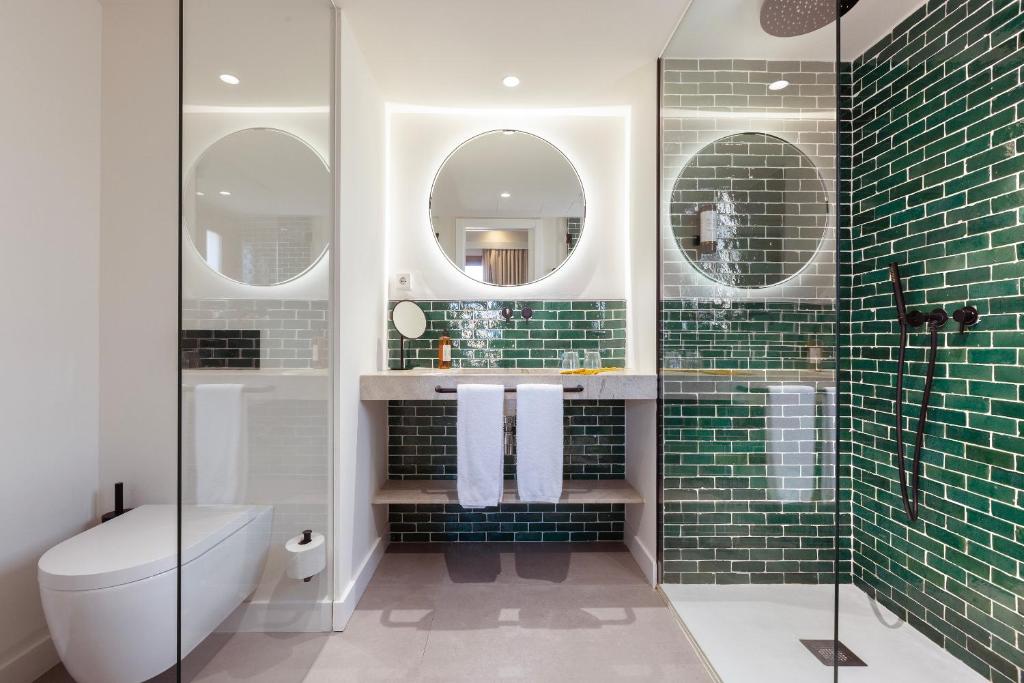 a bathroom with a shower and a toilet and two mirrors at Samaritana Suites in Palma de Mallorca