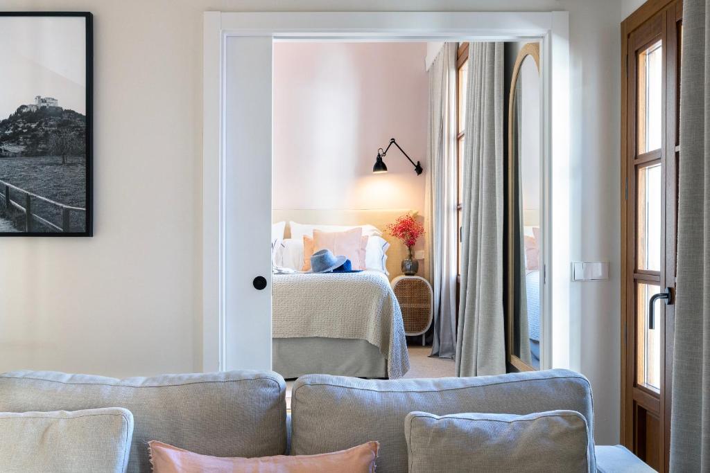 a room with a bed and a room with chairs at Samaritana Suites in Palma de Mallorca