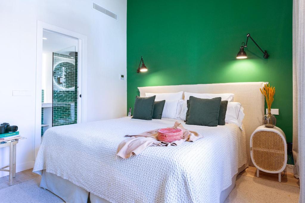 a bedroom with a white bed with a green wall at Samaritana Suites in Palma de Mallorca