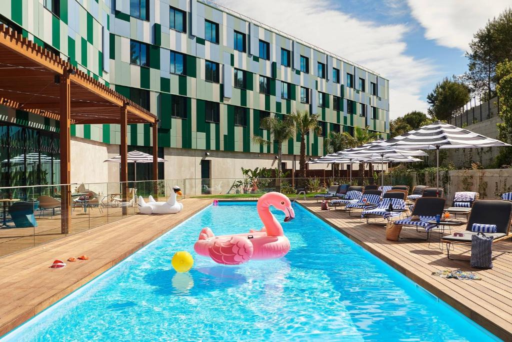 uma piscina com um flamingo rosa num hotel em Moxy Sophia Antipolis em Biot