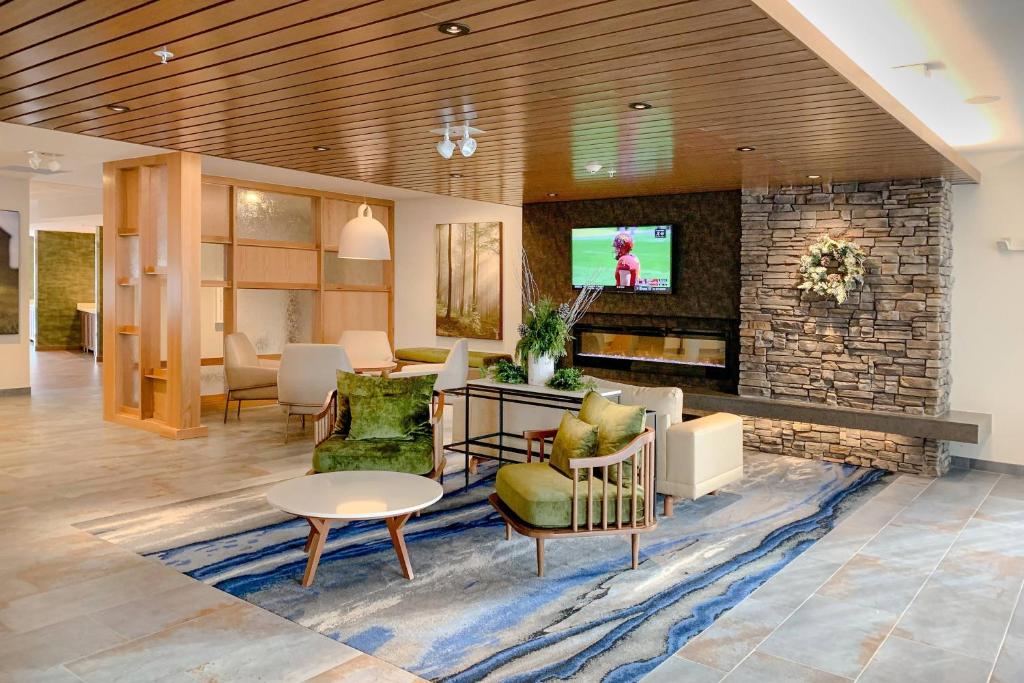 a lobby with a living room with a stone fireplace at Fairfield Inn & Suites by Marriott Northfield in Northfield