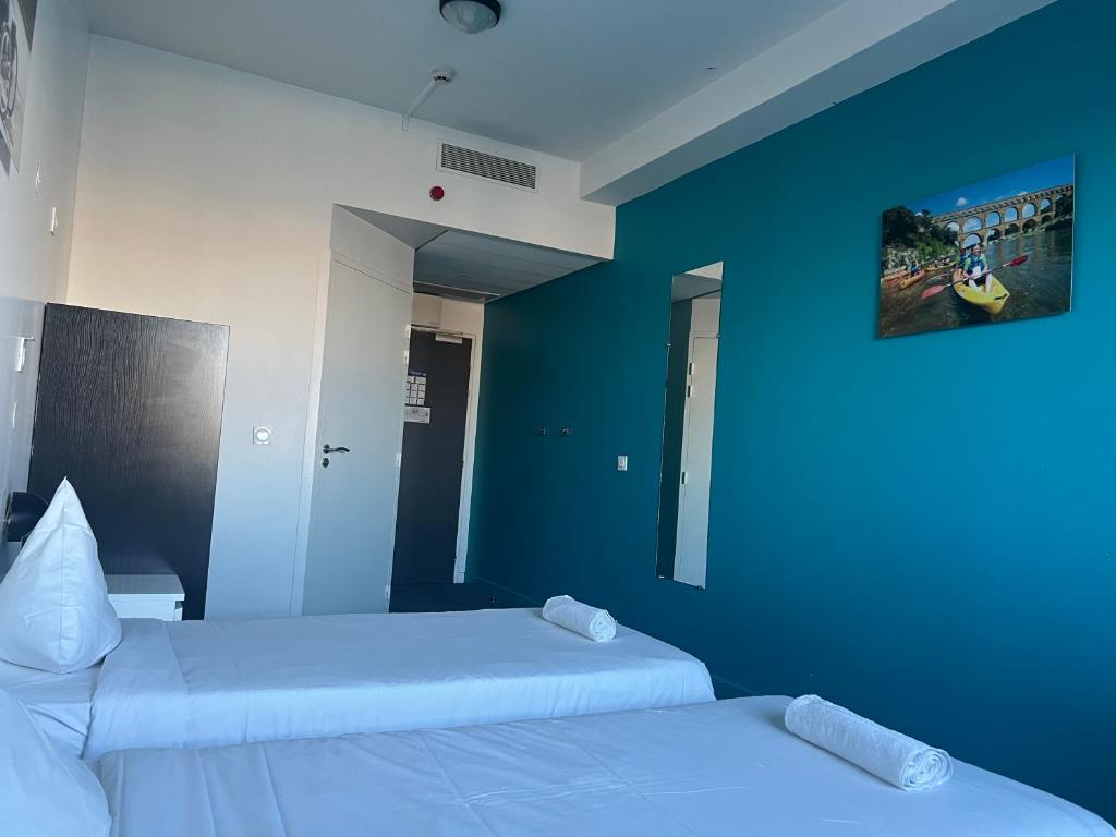 Duas camas num quarto com paredes azuis em Résidence Internationale De Paris em Paris