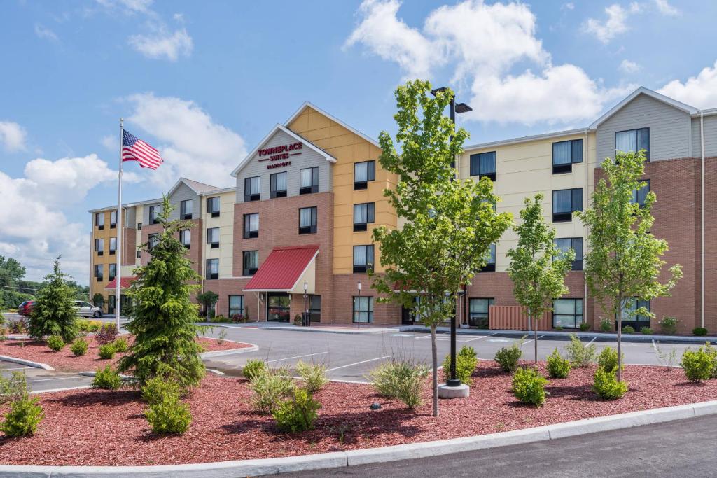 an exterior view of a hotel with an american flag at TownePlace Suites by Marriott New Hartford in New Hartford