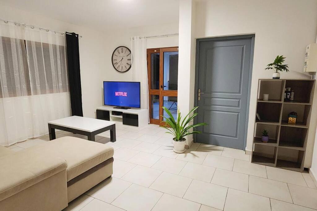 a living room with a couch and a tv at Appartement Nourou in Pamandzi