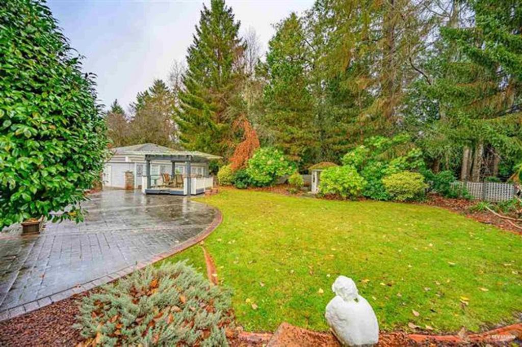 a yard with a house with a bird sitting in the grass at Ocean Park B&B in Surrey