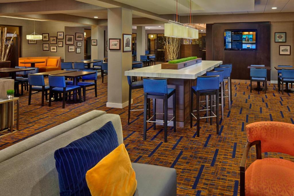 a restaurant with a bar with blue chairs and tables at Courtyard by Marriott Key West Waterfront in Key West