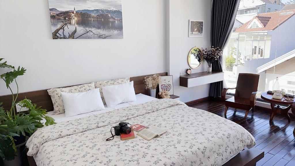 a bedroom with a bed with a book and a camera on it at Kaylin House in Xuan An