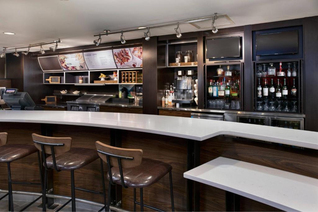 a bar with a white counter and stools at Courtyard Memphis Collierville in Collierville