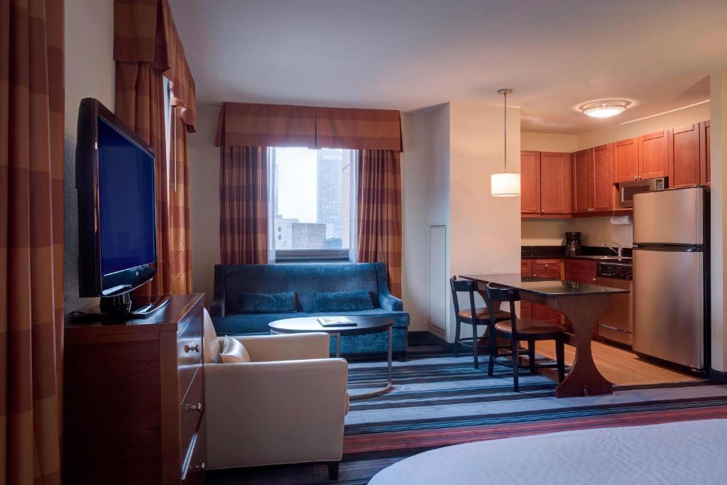 a living room with a couch and a kitchen at Residence Inn by Marriott New York Manhattan/Times Square in New York