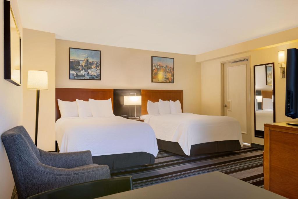 a hotel room with two beds and a chair at Residence Inn by Marriott New York Manhattan/Times Square in New York
