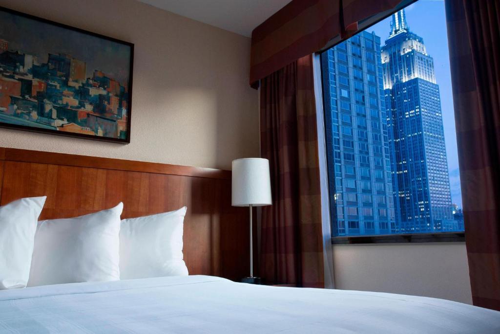 a bed in a hotel room with a large window at Residence Inn by Marriott New York Manhattan/Times Square in New York