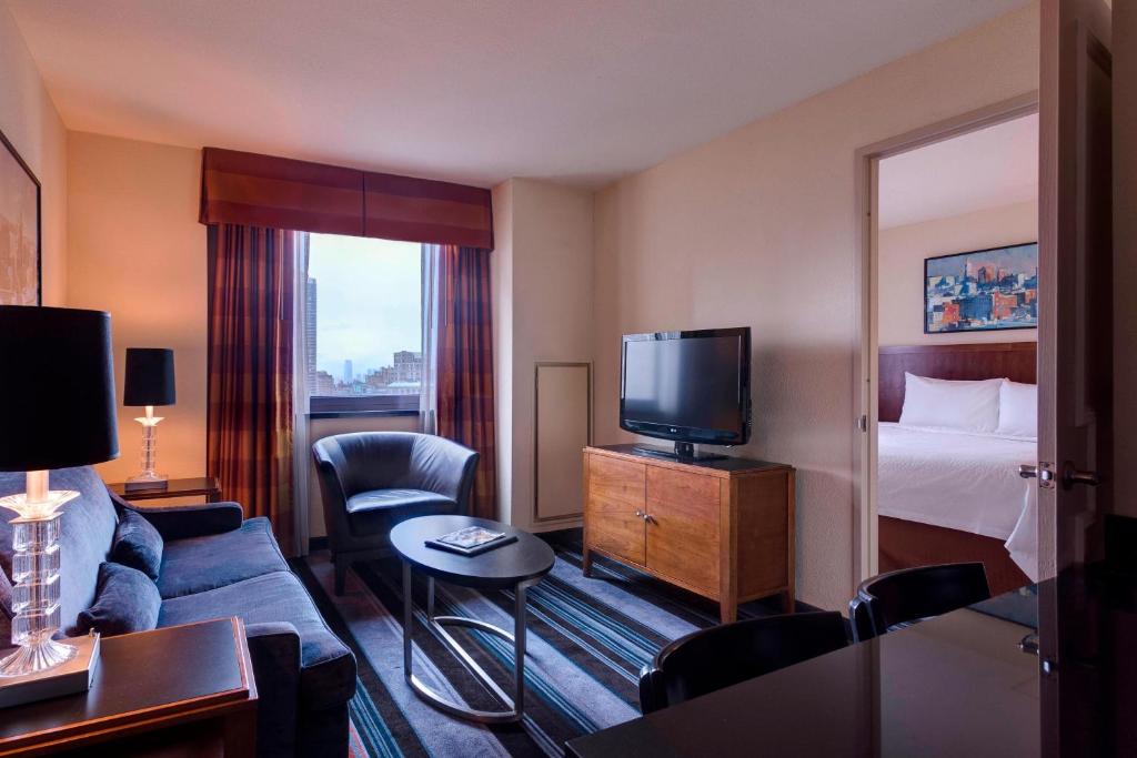 a hotel room with a couch and a bed and a television at Residence Inn by Marriott New York Manhattan/Times Square in New York