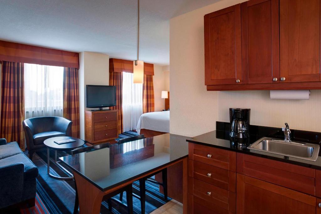 a hotel room with a kitchen and a bedroom at Residence Inn by Marriott New York Manhattan/Times Square in New York