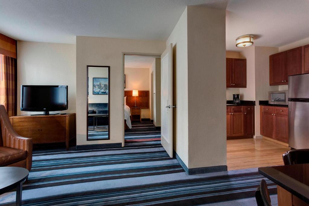 a living room with a television and a kitchen at Residence Inn by Marriott New York Manhattan/Times Square in New York
