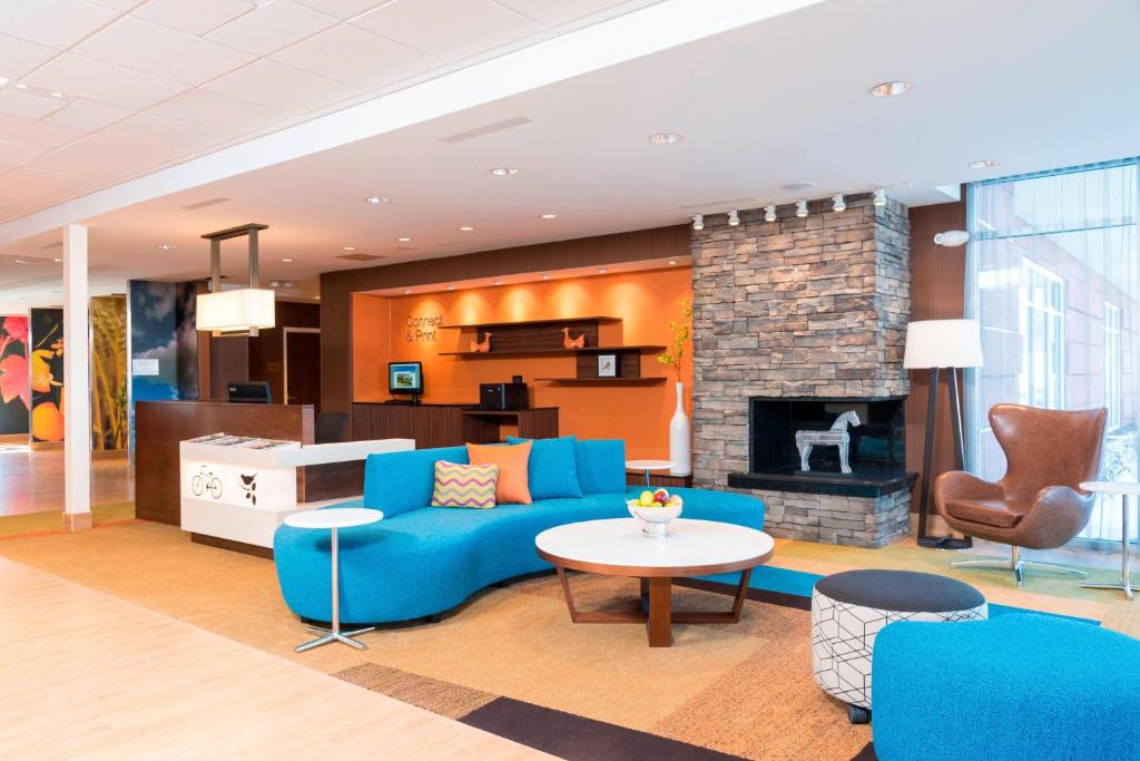 a living room with a blue couch and a fireplace at Fairfield Inn & Suites by Marriott Indianapolis Fishers in Fishers