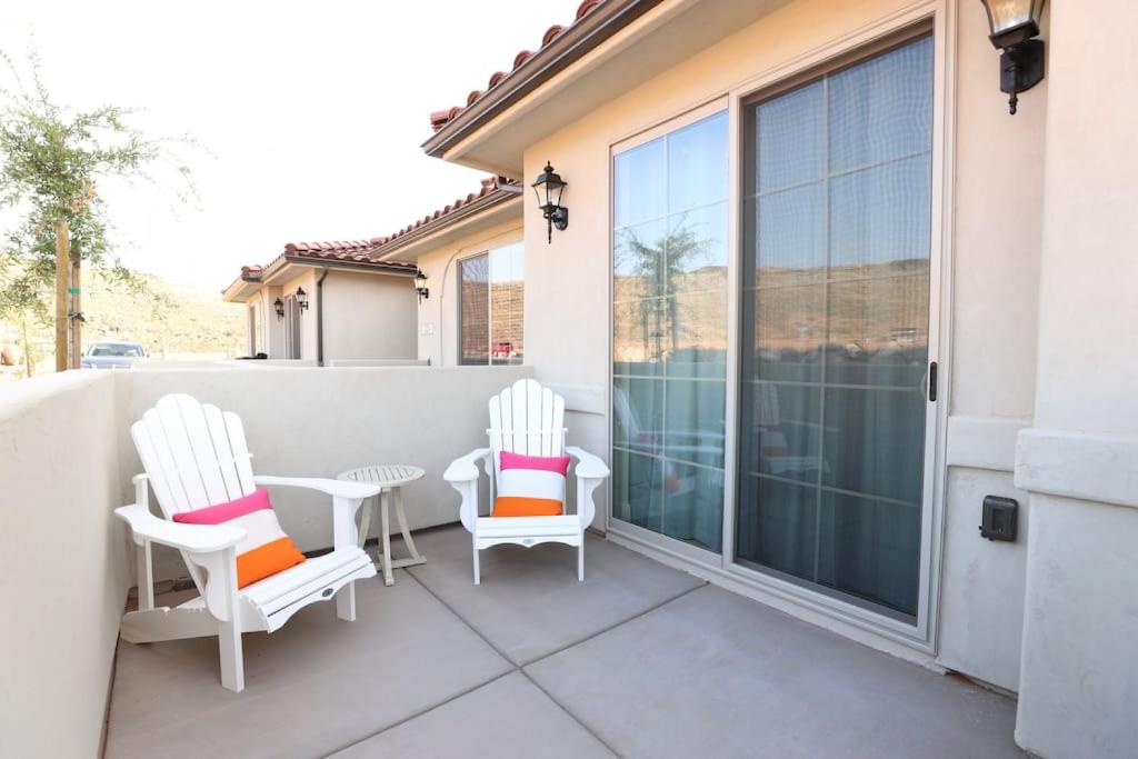 eine Terrasse mit zwei Stühlen und einem Tisch auf einem Balkon in der Unterkunft Red Sands Retreat with Pool Pickleball and Zion NP in Washington