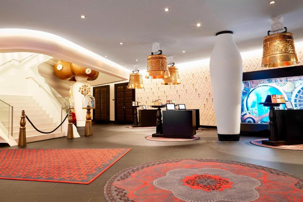 a lobby with a room with a red rug and a large white vase at Kameha Grand Zurich, Autograph Collection in Glattbrugg