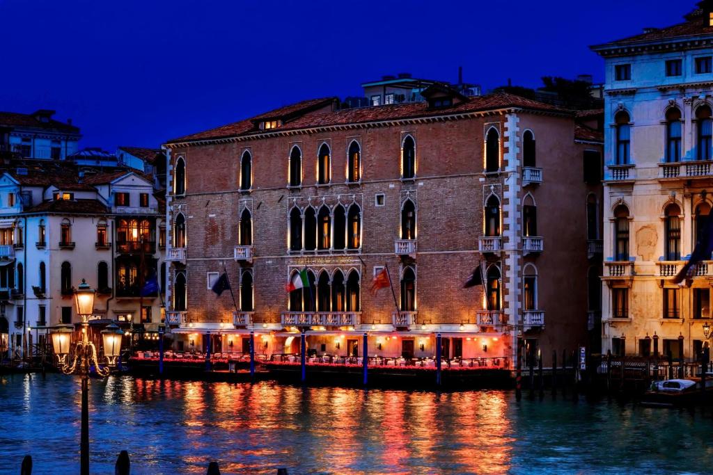 a group of buildings on the water at night at The Gritti Palace, a Luxury Collection Hotel, Venice in Venice