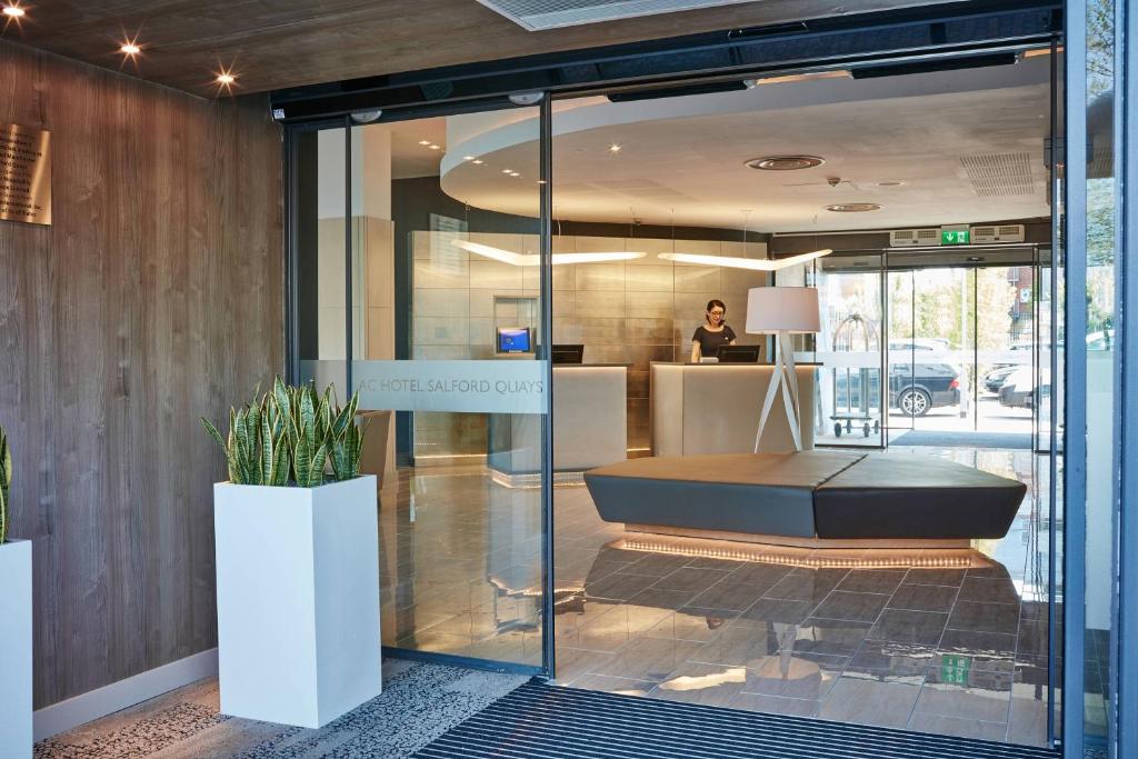 an office with a glass door with a bench in it at AC Hotel by Marriott Manchester Salford Quays in Manchester