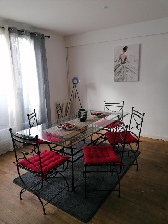 une salle à manger avec une table en verre et quatre chaises dans l'établissement Appartement entier Bourges Avaricum centre ville, à Bourges