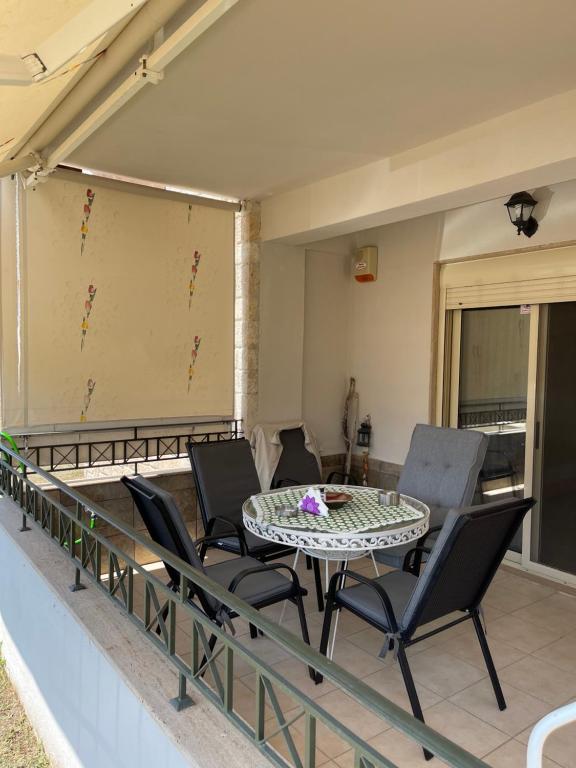 patio con mesa y sillas en el balcón en MP house, en Kallithea Halkidikis