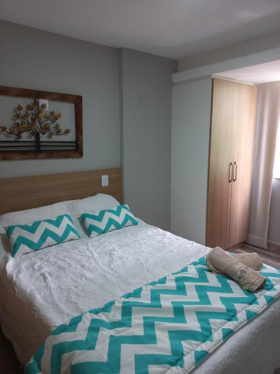 a bedroom with a bed with blue and white at Flat Beverly Hills 101A in Vila Velha