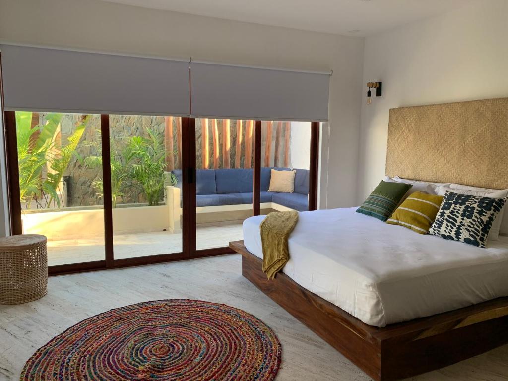 芝華塔尼歐的住宿－Luana Suites- Suite Maya，一间卧室设有一张床和一个大窗户