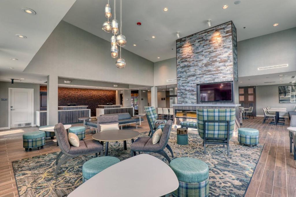 a lobby with tables and chairs and a fireplace at Residence Inn by Marriott Providence Lincoln in Lincoln