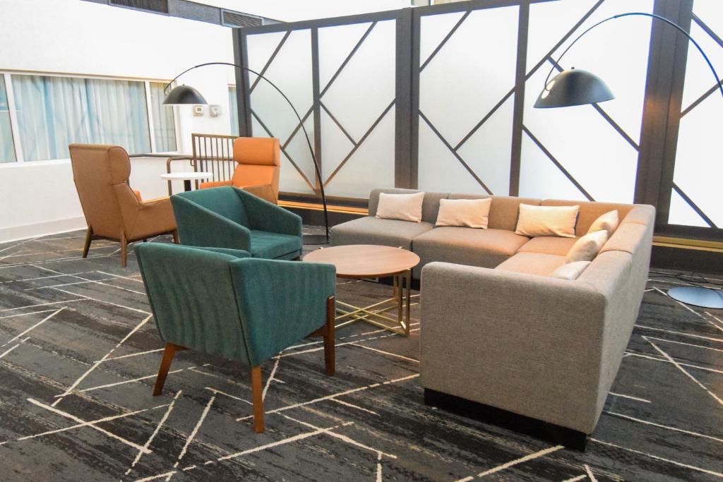 a living room with couches and chairs and a table at Delta Hotels by Marriott Little Rock West in Little Rock