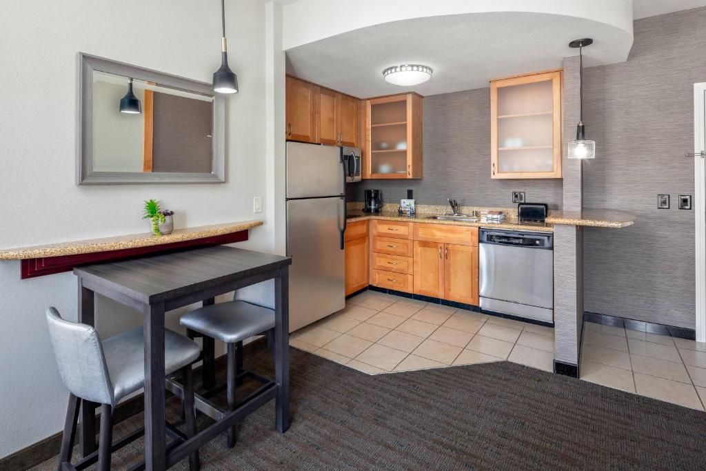 a kitchen with a table and a refrigerator at Residence Inn Phoenix NW/Surprise in Surprise