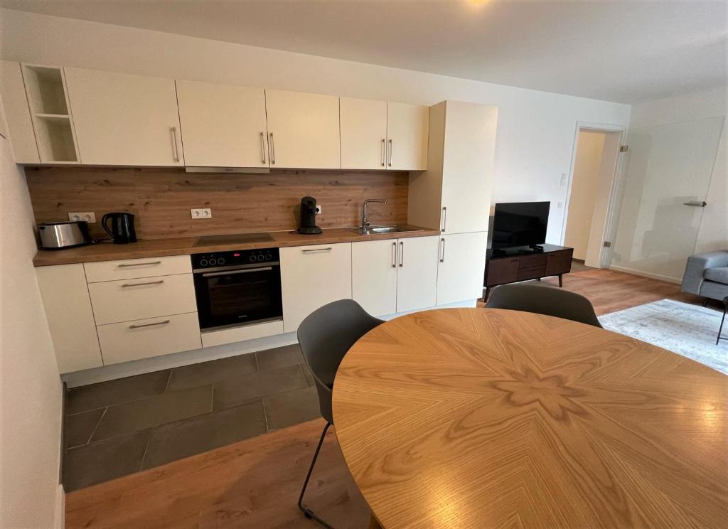 een keuken met een houten tafel en een eetkamer bij helloYOU Apartments in Ingelheim am Rhein