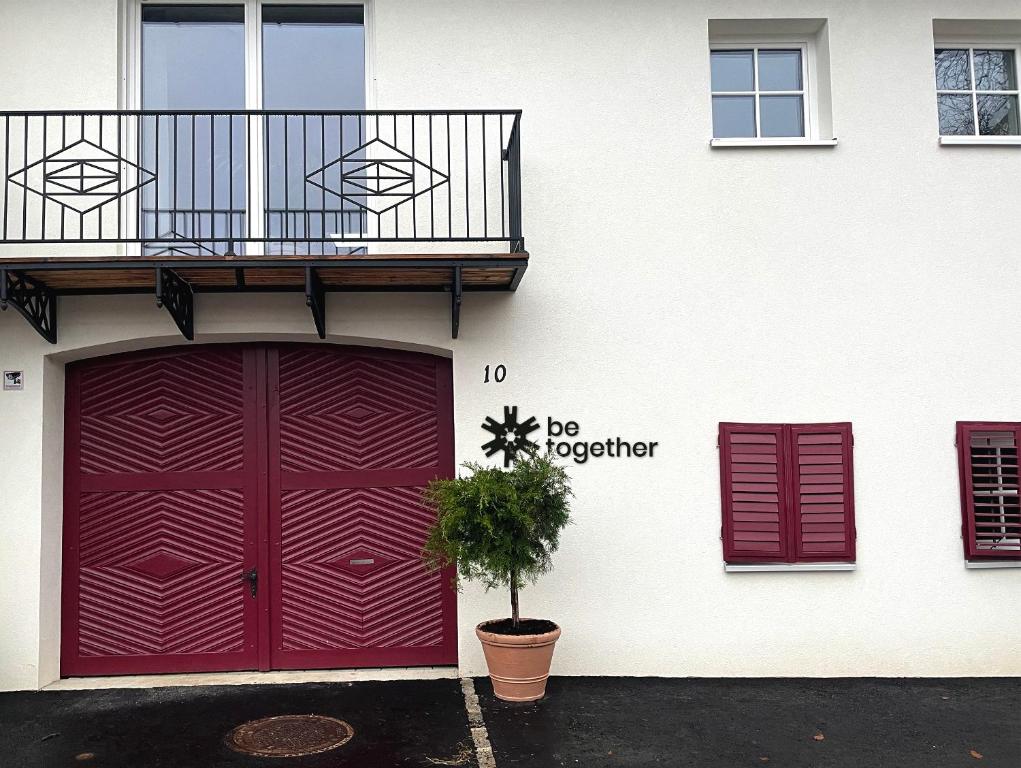 um edifício com uma porta vermelha e uma varanda em "be-together" Engabrunn em Engabrunn