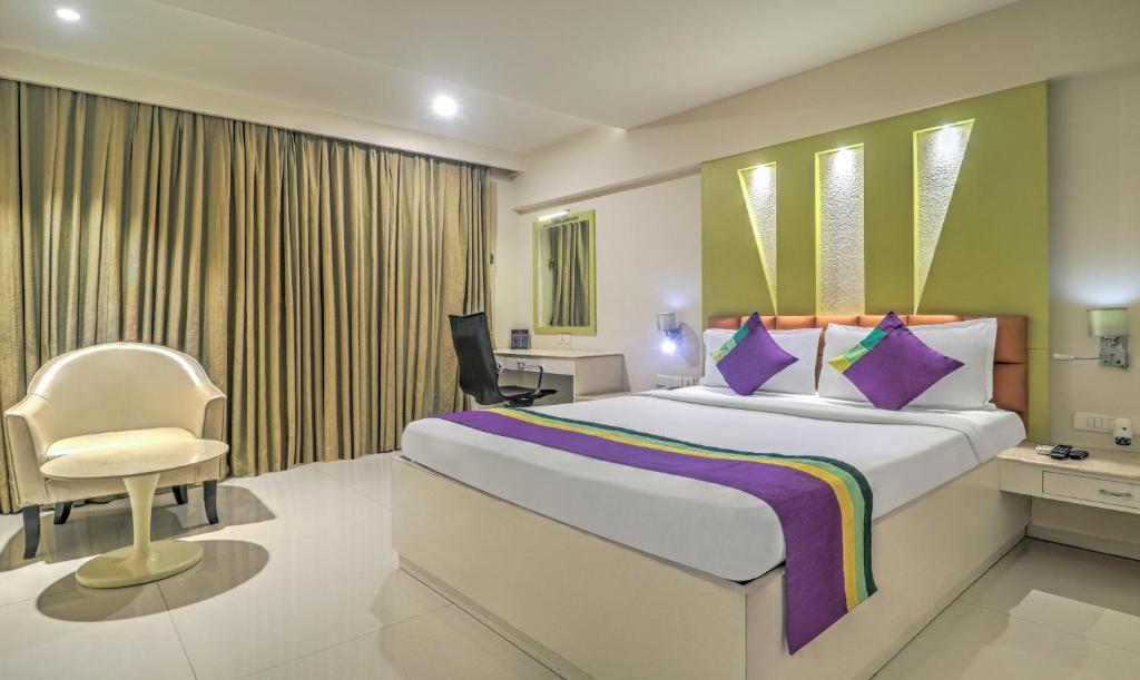 a bedroom with a bed and a desk and a chair at Treebo Tryst Metropolis in Hyderabad