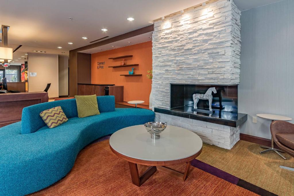 a living room with a blue couch and a fireplace at Fairfield Inn & Suites by Marriott Elkhart in Elkhart