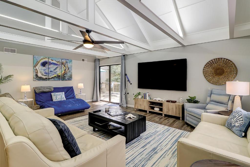 uma sala de estar com um sofá e uma televisão em Queens Grant em Hilton Head Island