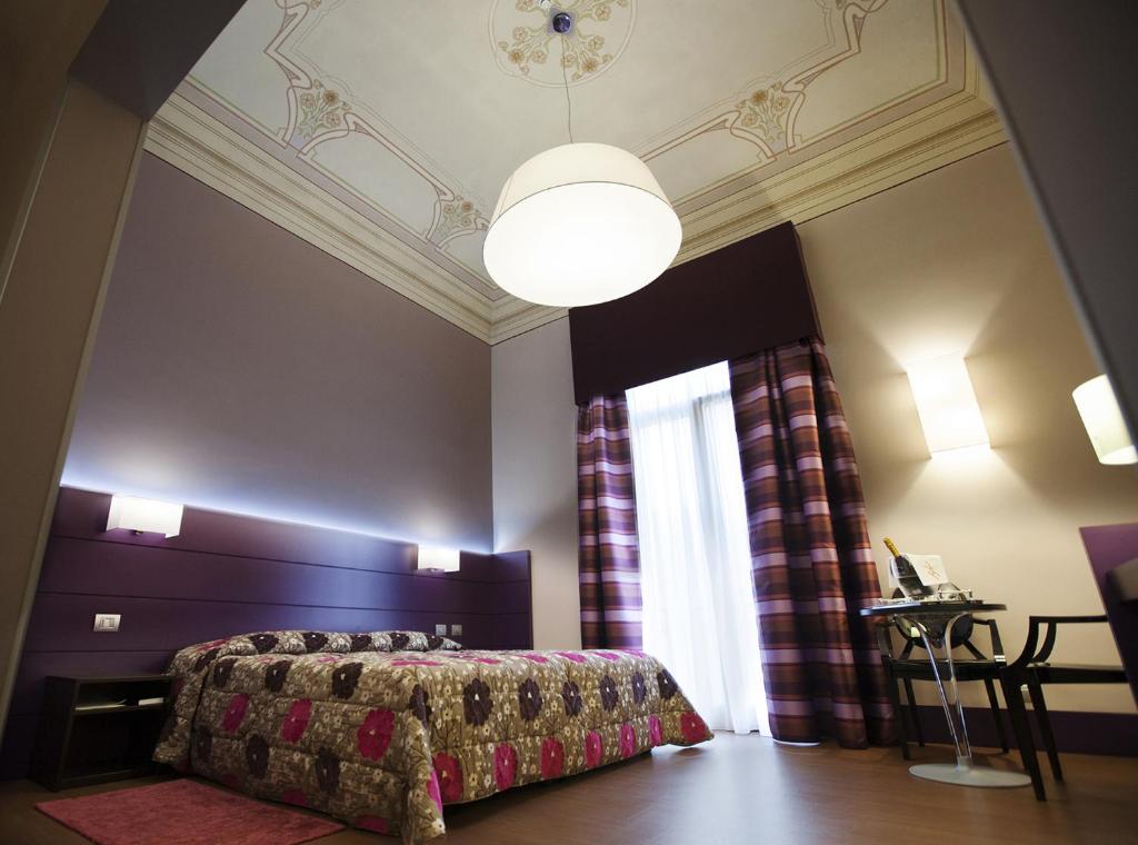 
a hotel room with a large bed and a large window at Hotel Vittoria in Trapani
