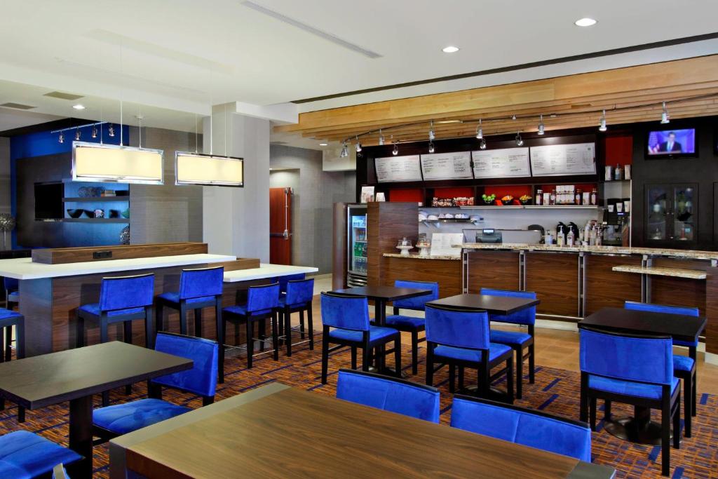 um restaurante com cadeiras e mesas azuis e um bar em Courtyard by Marriott Victoria em Victoria