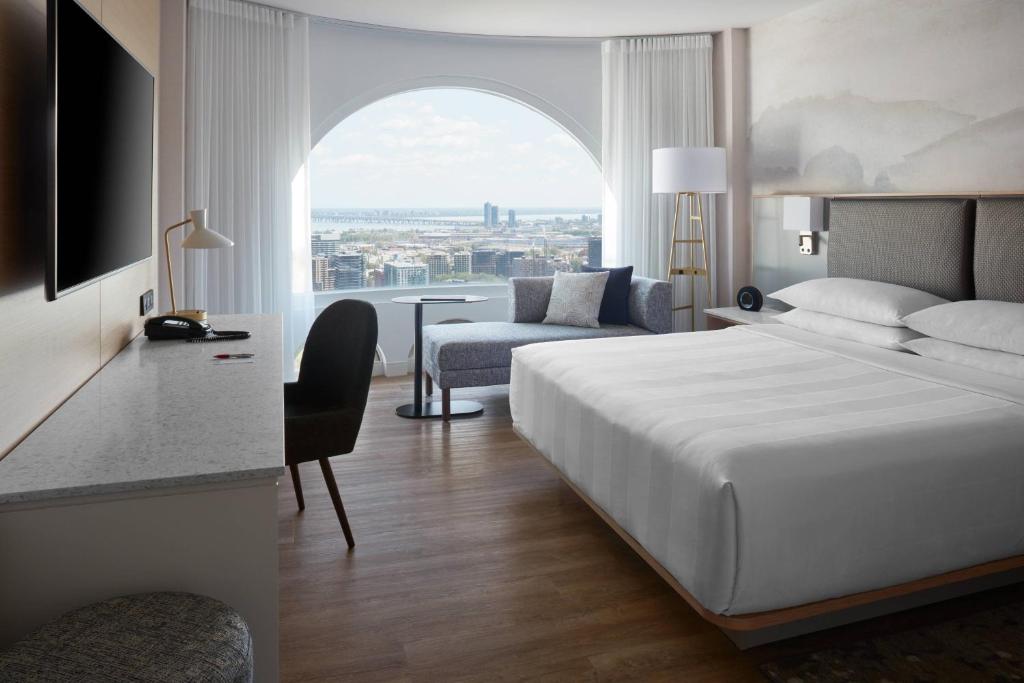 um quarto de hotel com uma cama e uma cadeira e uma janela em Montreal Marriott Chateau Champlain em Montreal