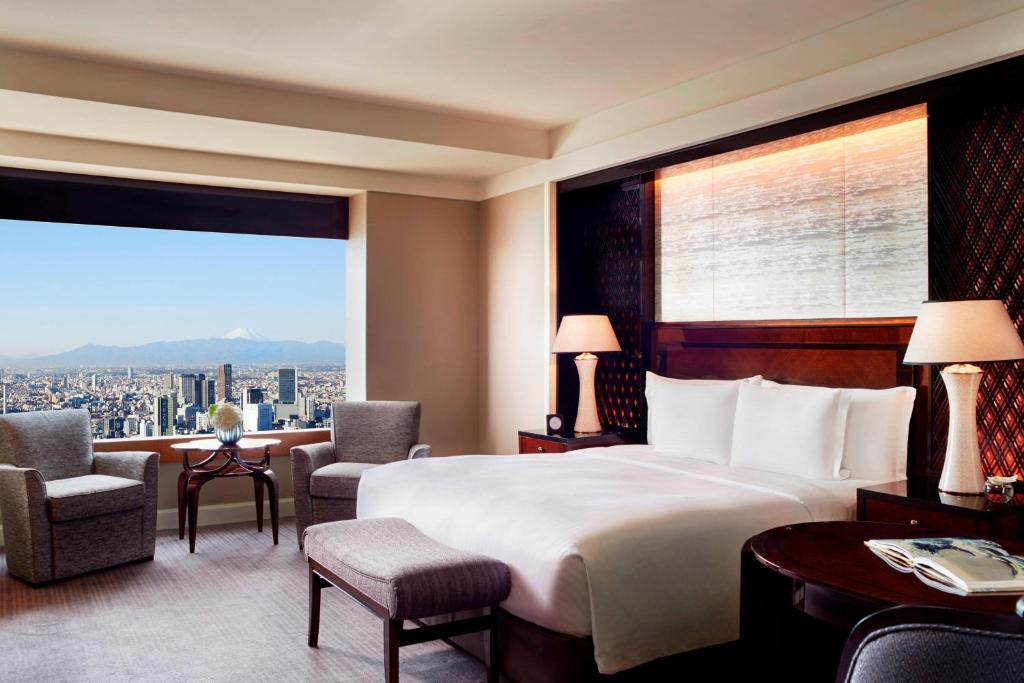 a hotel room with a large bed and a large window at The Ritz-Carlton, Tokyo in Tokyo