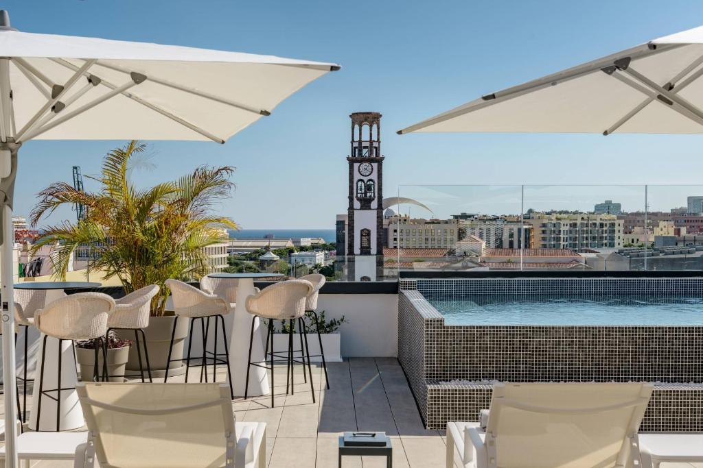 a rooftop bar with chairs and a swimming pool at AC Hotel by Marriott Tenerife in Santa Cruz de Tenerife