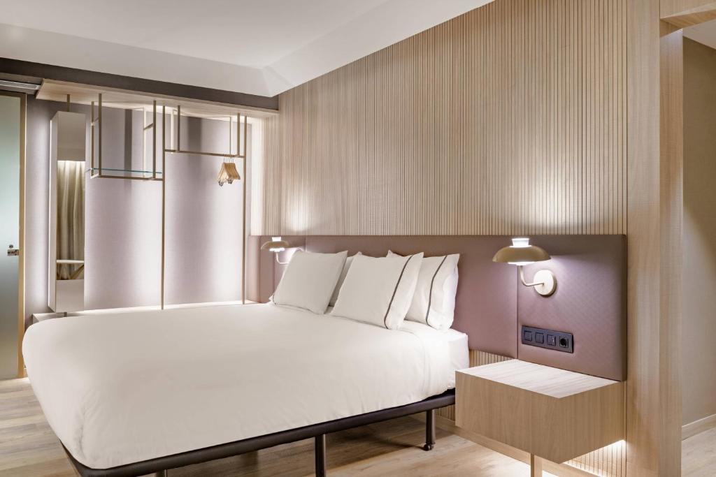 a bedroom with a large white bed and a table at AC Hotel by Marriott Tenerife in Santa Cruz de Tenerife